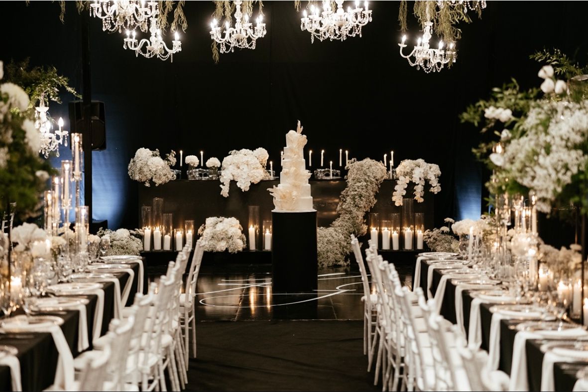 Black and white ballroom wedding in Cyprus with a tiered cake and candlelit tables