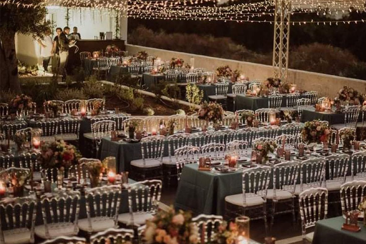 Evening wedding reception in Paphos with long tables under a canopy of fairy lights